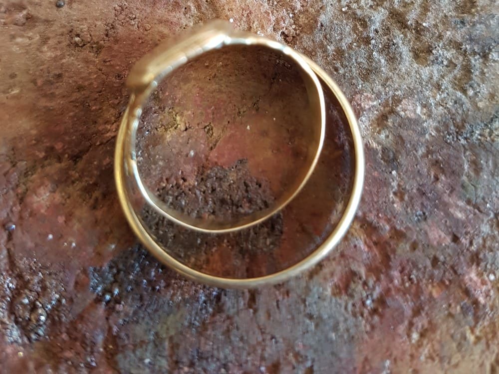 Twee oude gouden trouwringen over elkaar op de soldeersteen
